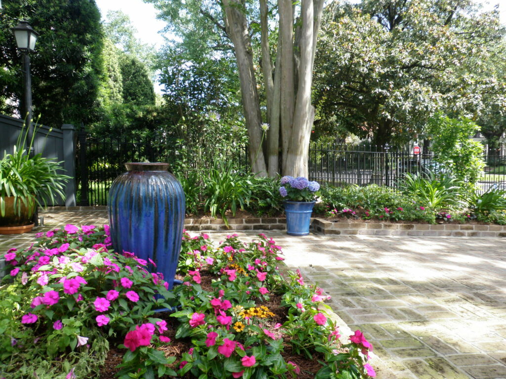 new orleans courtyard with blue urn pink flowers