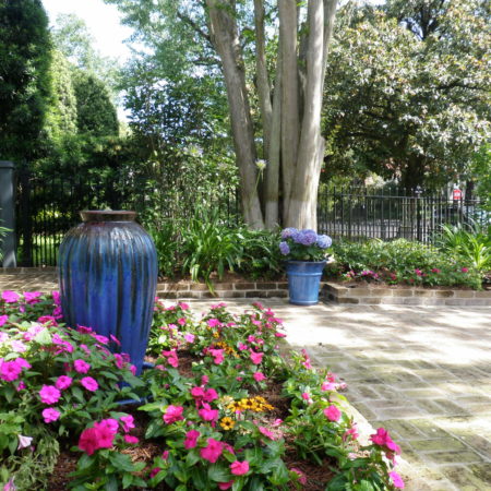 new orleans courtyard with blue urn pink flowers